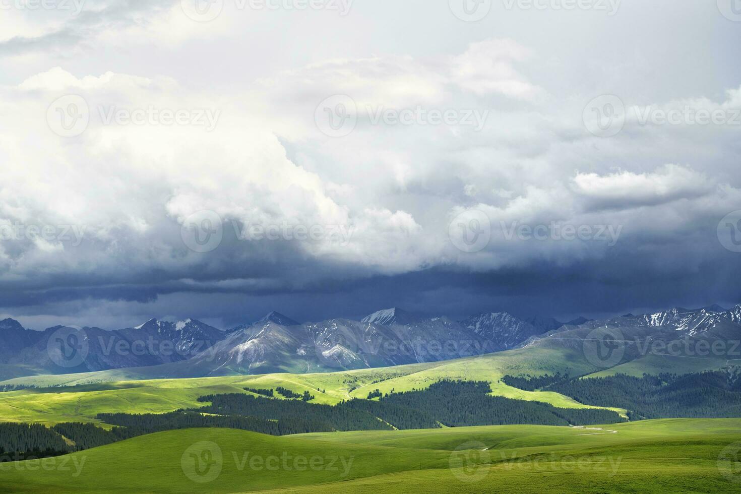 Grassland and mountains in a cloudy day. Photo in Kalajun grassland in Xinjiang, China.