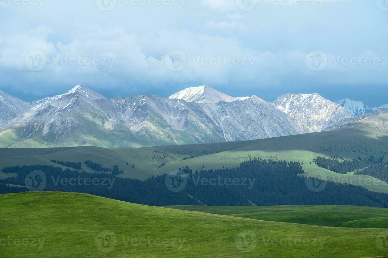 Grassland and snowy mountain in a cloudy day. Photo in Kalajun grassland in Xinjiang, China.