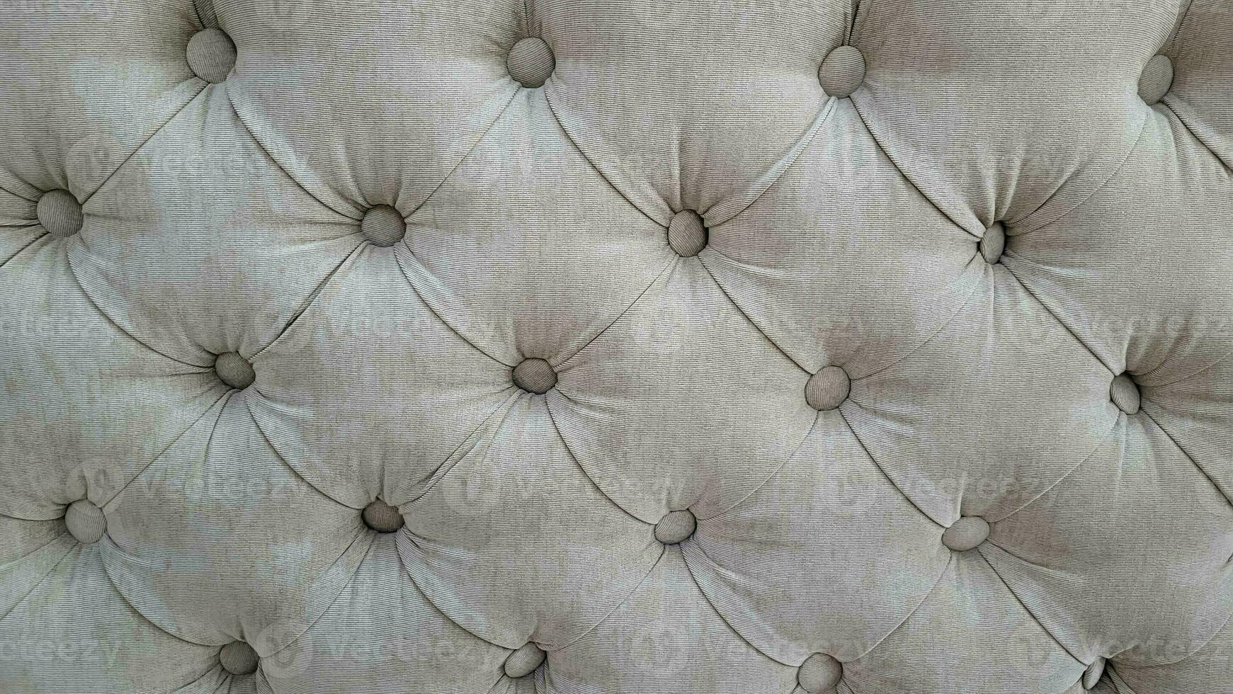 Grey velour background with quilted upholstery in Chesterfield style close-up. photo