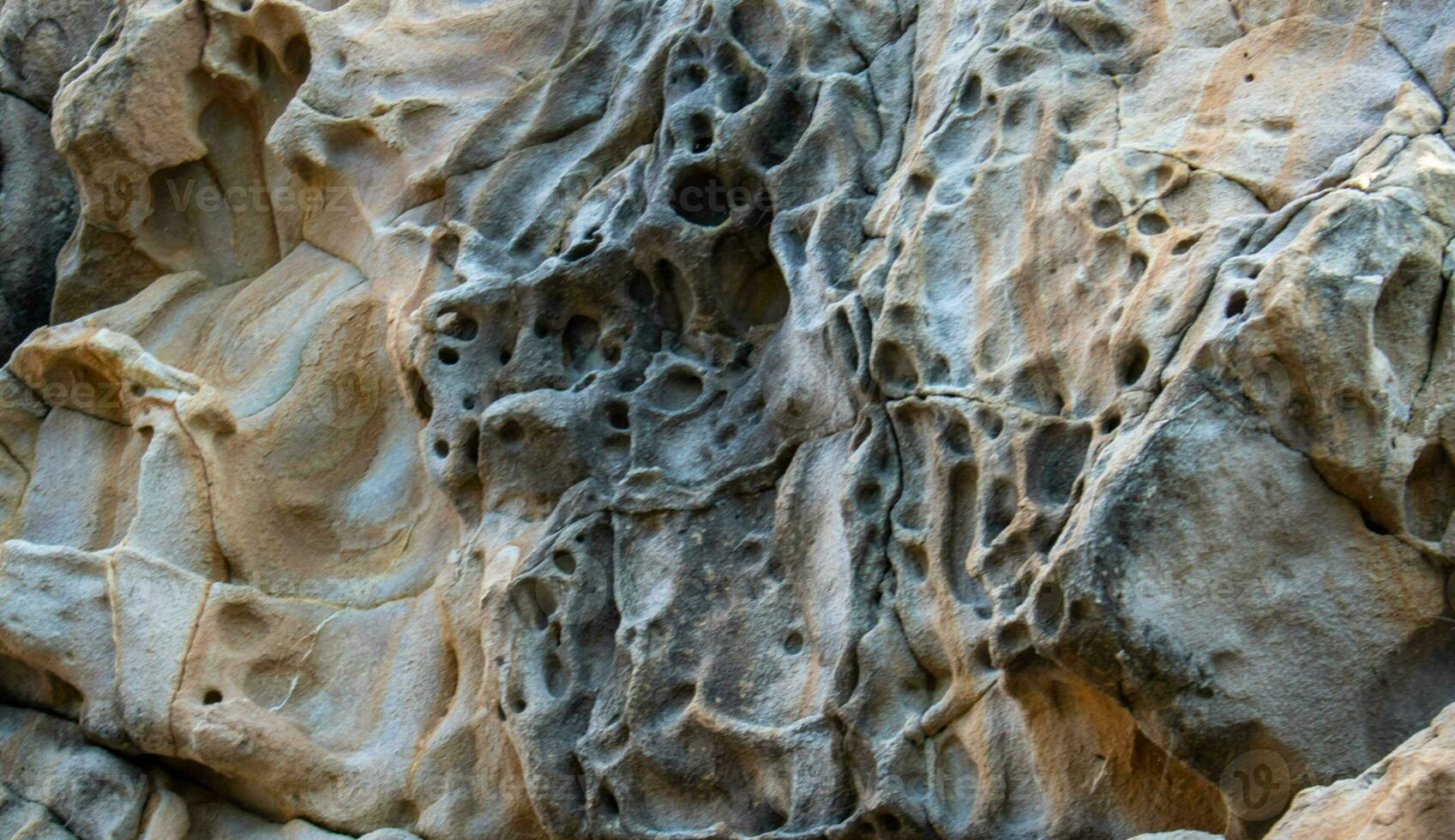 Texture, background layers and cracks in sedimentary rock on cliff face. Cliff of rock mountain. Seamless abstract background. Cracks and layers of sandstone. photo