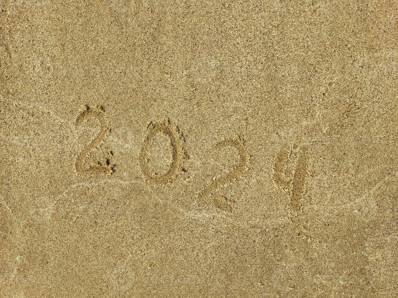The numbers 2024 are written on the sandy beach. The concept of the new year. photo