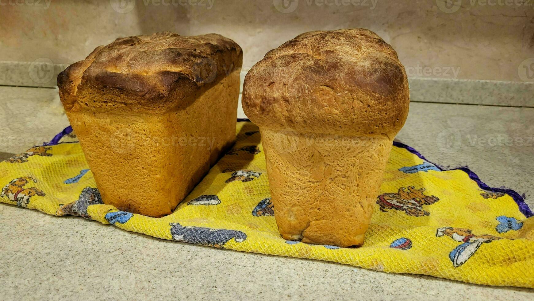 Homemade freshly baked bread lies on a towel on the table. photo