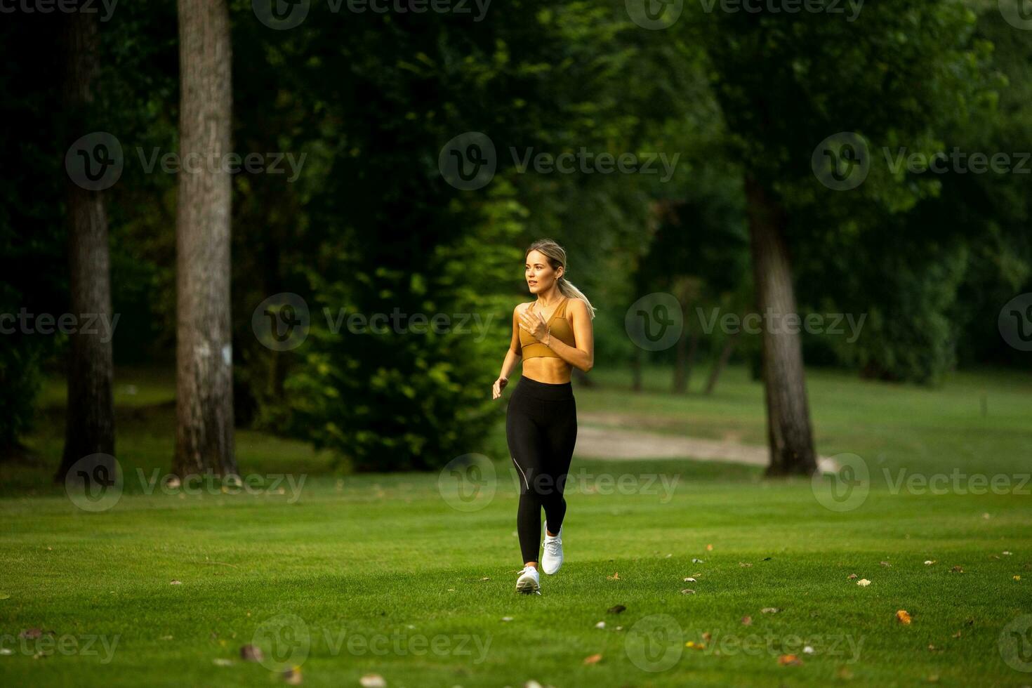 Pretty young woman running in the park photo