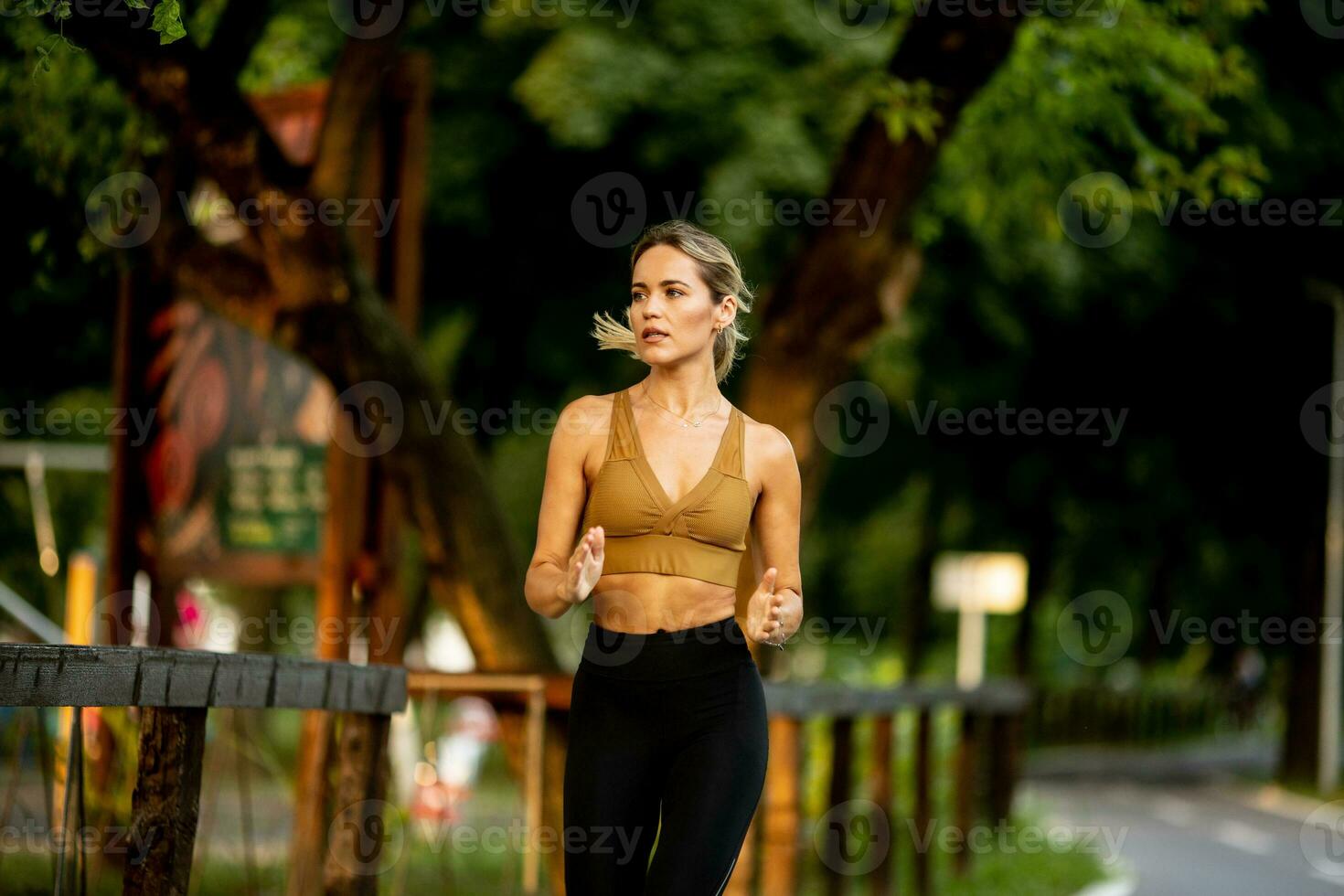 bonito joven mujer corriendo en el carril en el parque foto