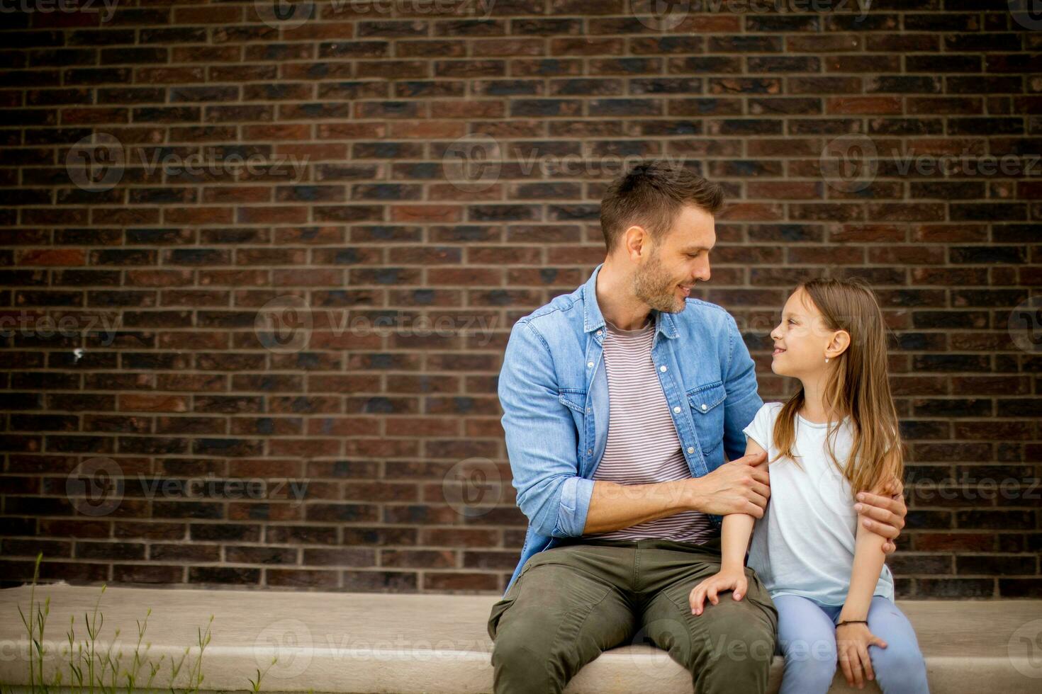 padre y su hija tener un bueno hora en frente de casa puerta foto