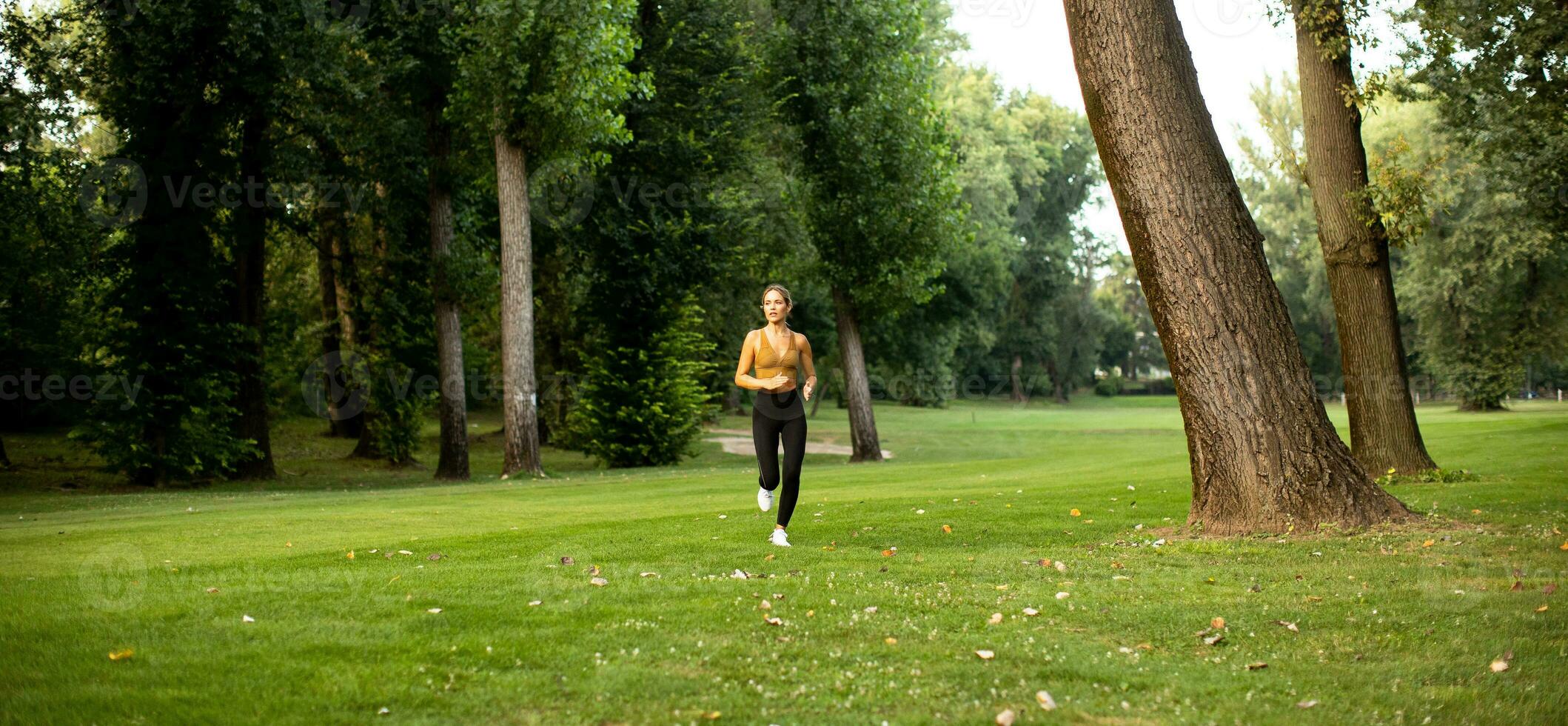 bonito joven mujer corriendo en el parque foto