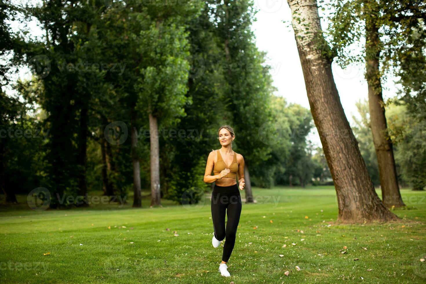 bonito joven mujer corriendo en el parque foto