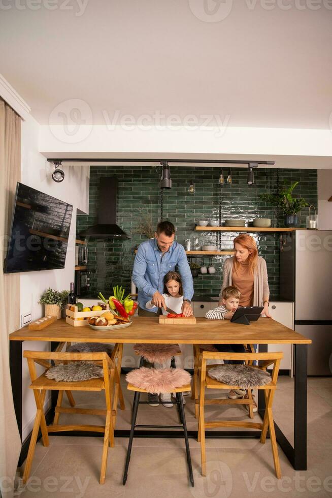 Young family preparing vegetables in the kitchen photo