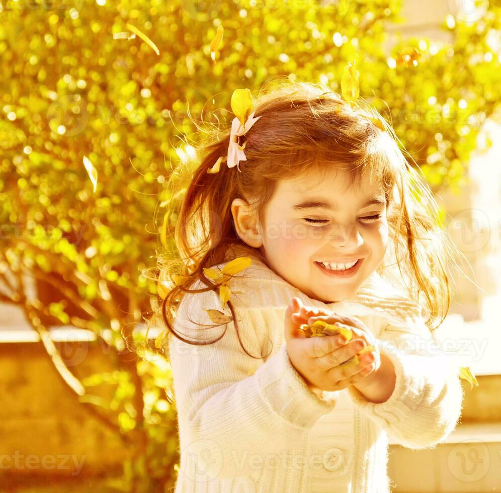 Happy little girl in autumn park photo