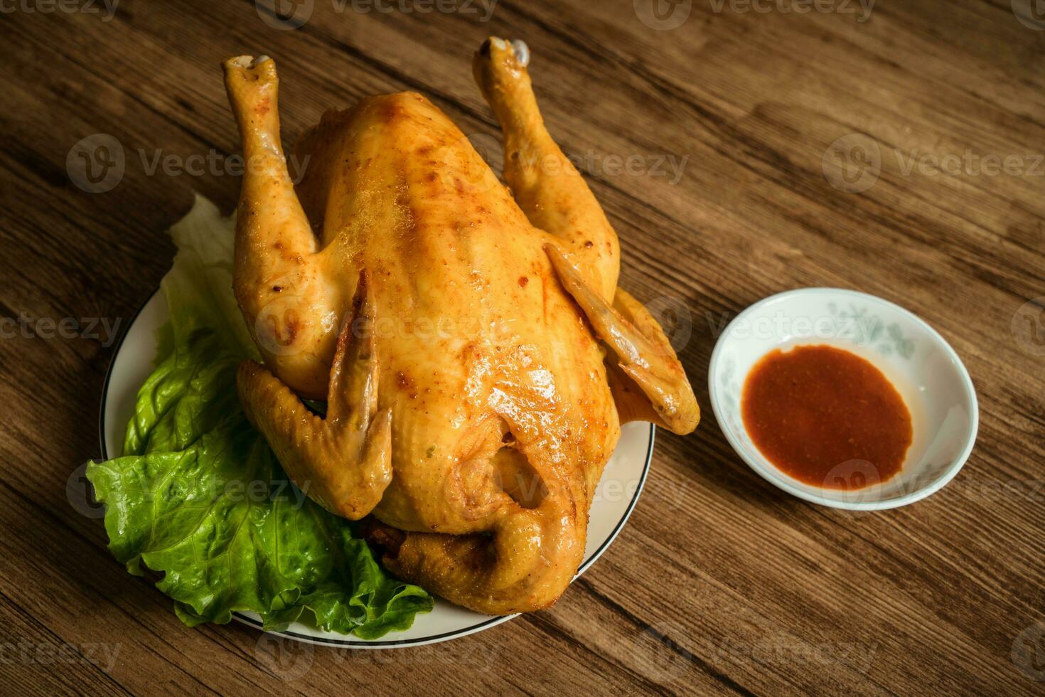 Roast chicken on the wooden table photo