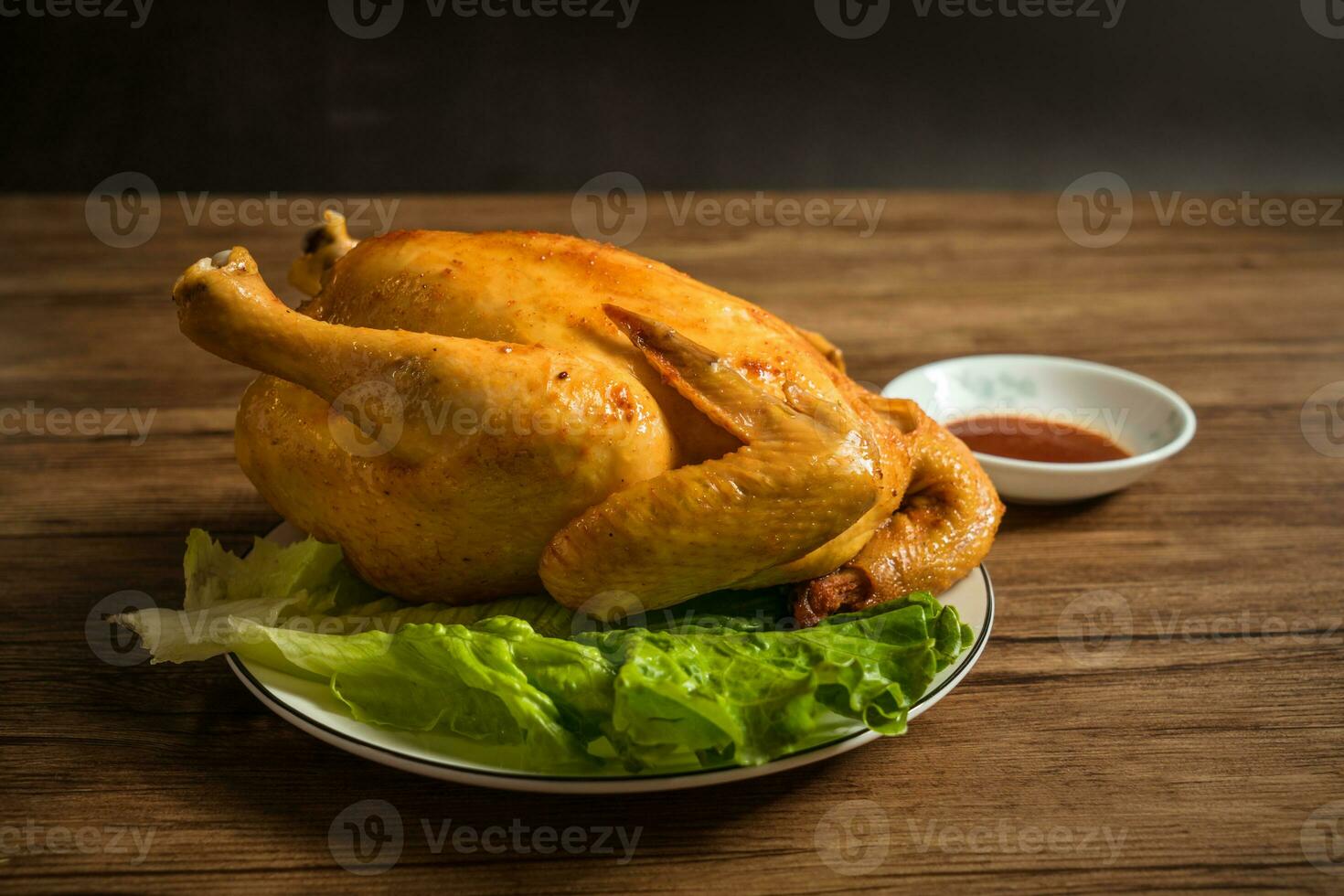 Roast chicken on the wooden table photo