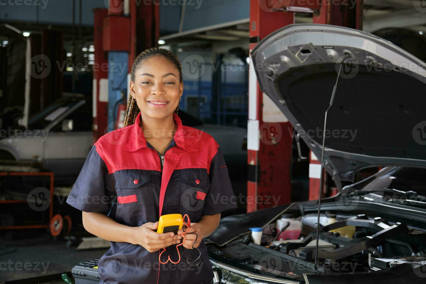 One Black female professional automotive mechanical worker checks an EV car battery and hybrid engine at a maintenance garage, expert electric vehicle service, and fixing occupations auto industry. photo
