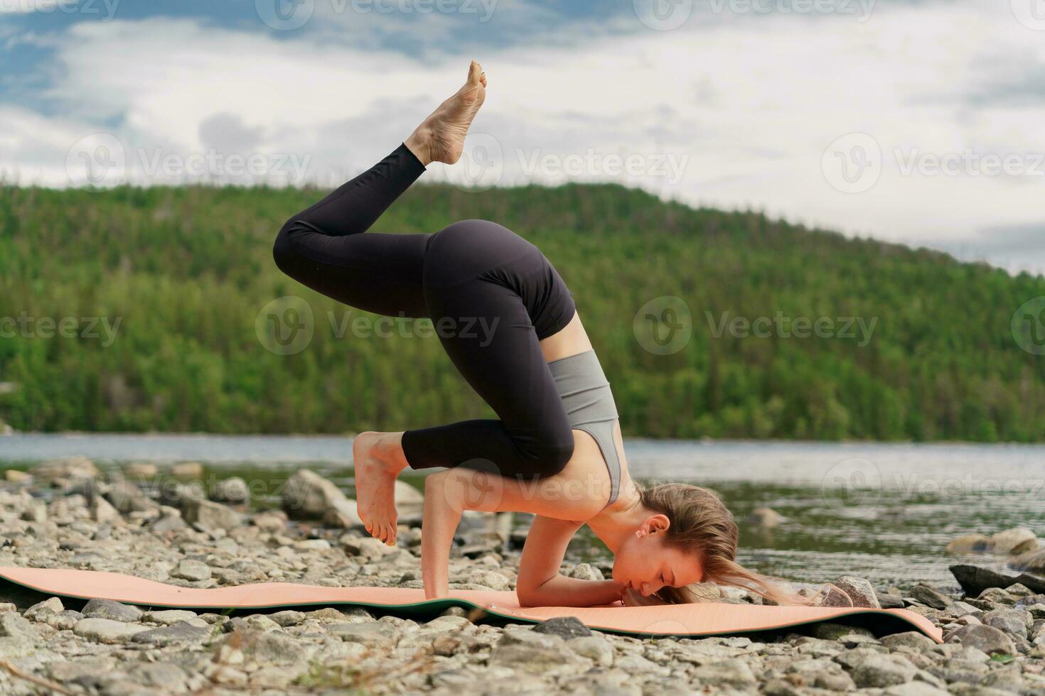 Training in nature, improves Pilates and stretching. Confident and harmony in a healthy human body.  The trainer doing the yoga asana exercise, uses a mat. photo