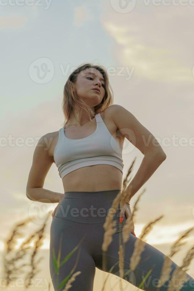 Meditative harmony and balance of a person, mental health. The woman is  slender, flexible body, practicing yoga exercise beautiful asana. Fitness  on the background of sunset. 27885859 Stock Photo at Vecteezy