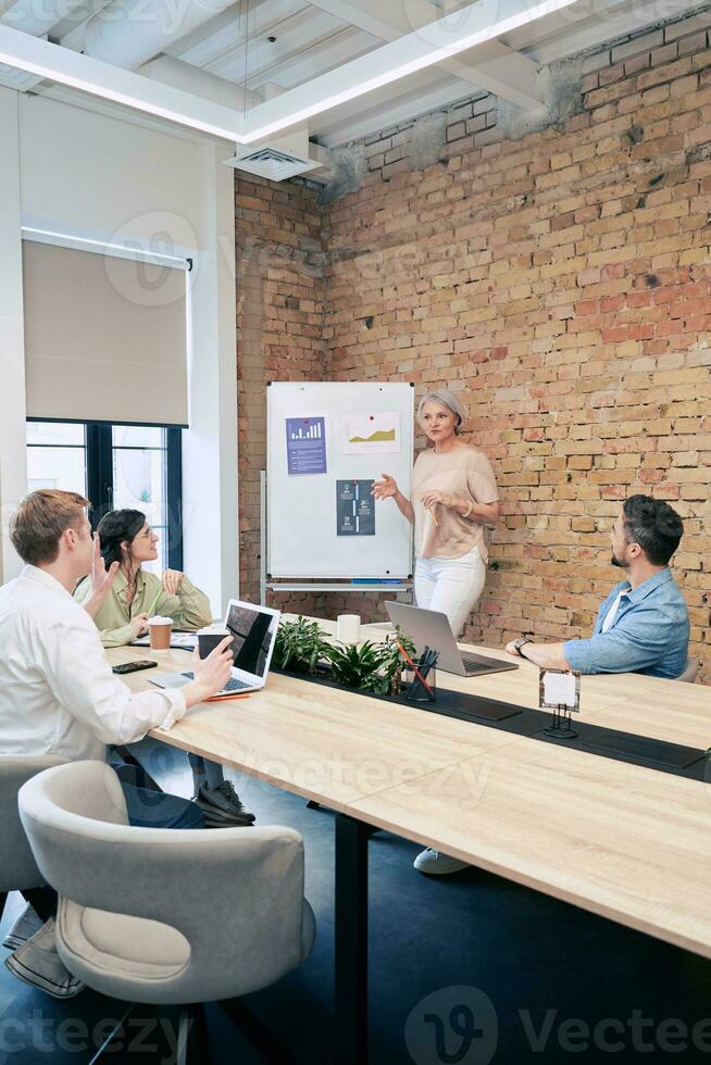 Businesswoman discussing company presentation with colleagues in conference room meeting. Startup, coworking, management concept photo