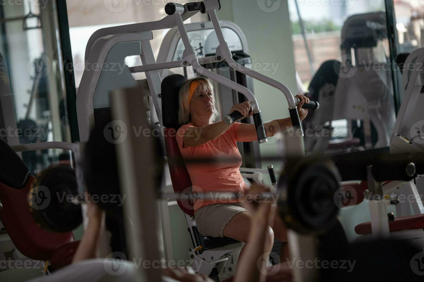 un justa peludo mayor mujer trabajando fuera en un gimnasio foto