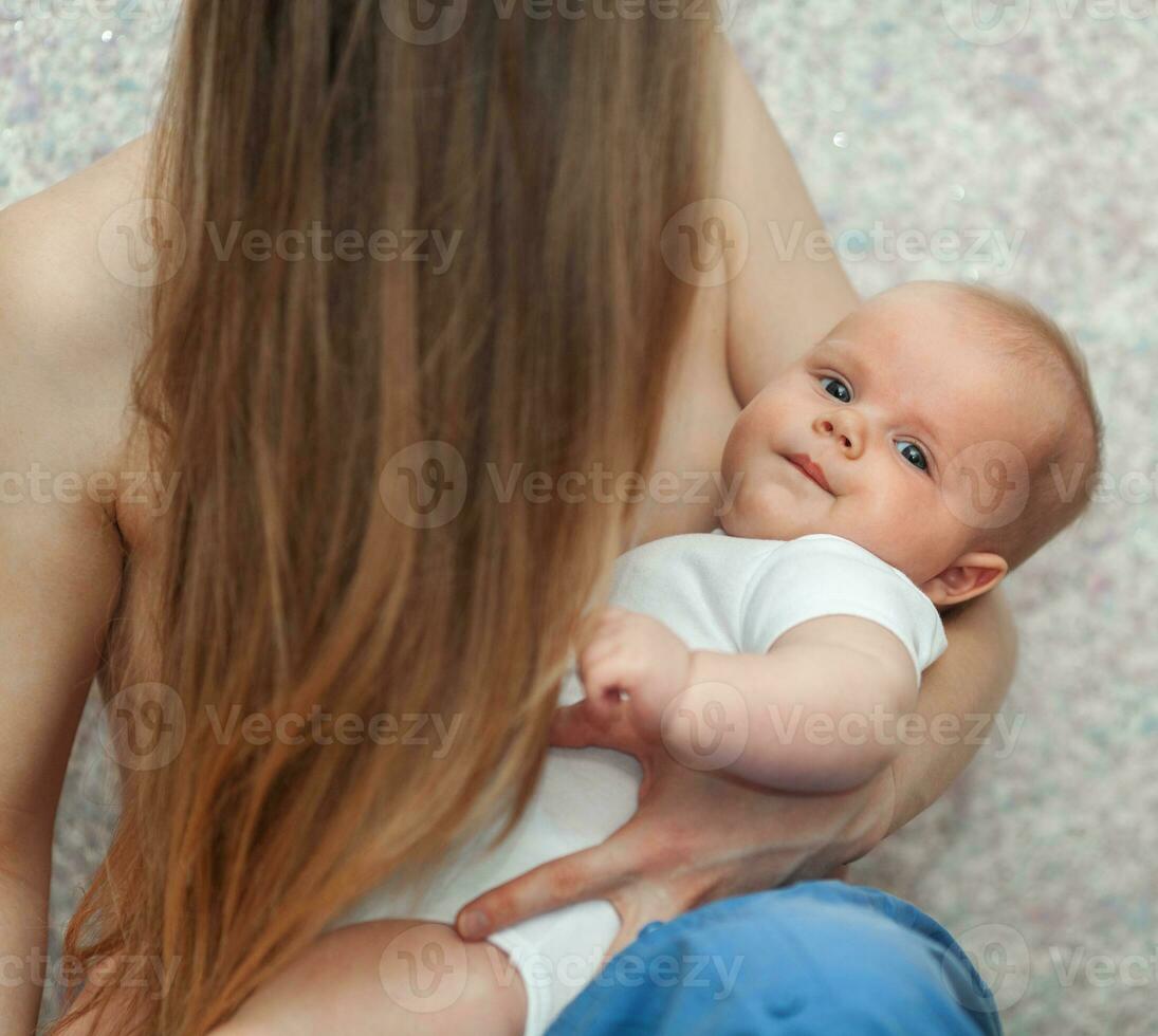 Baby in hands of loving and caring mother photo