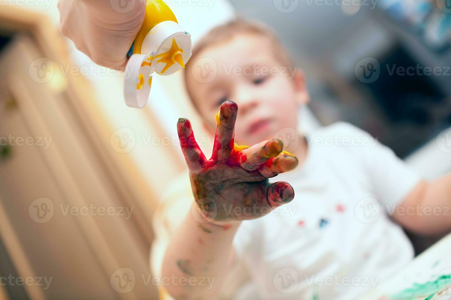 Pressing finger-paint on boys hand photo