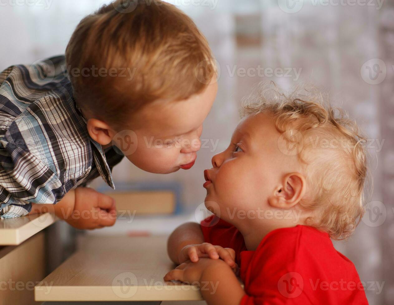Cute siblings. Two little brothers are kissing. photo