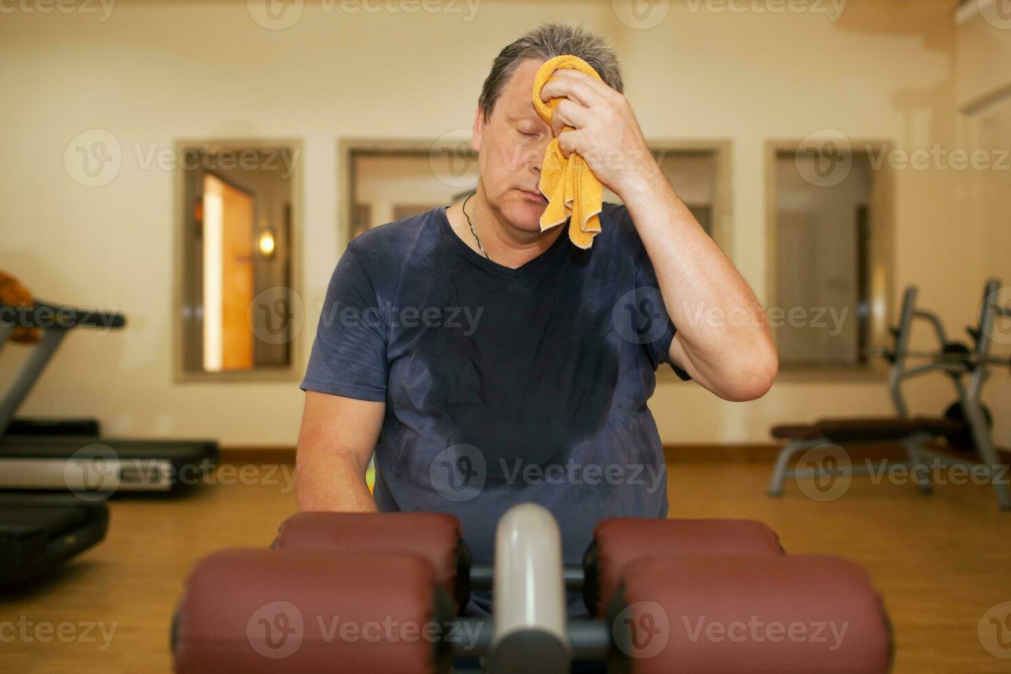 cansado hombre limpiando sudor después rutina de ejercicio foto