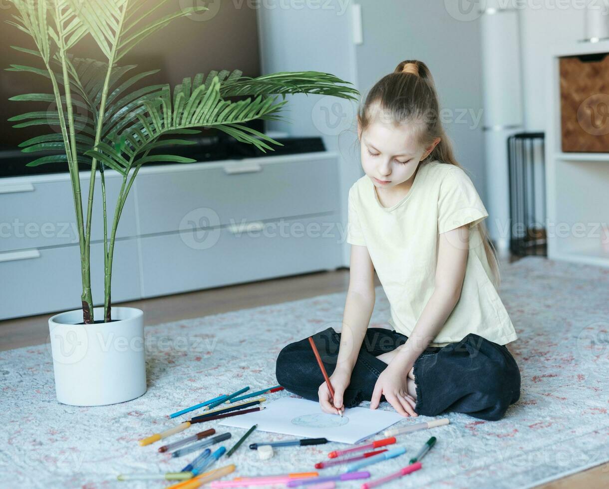 Child girl drawing with colorful pencils photo