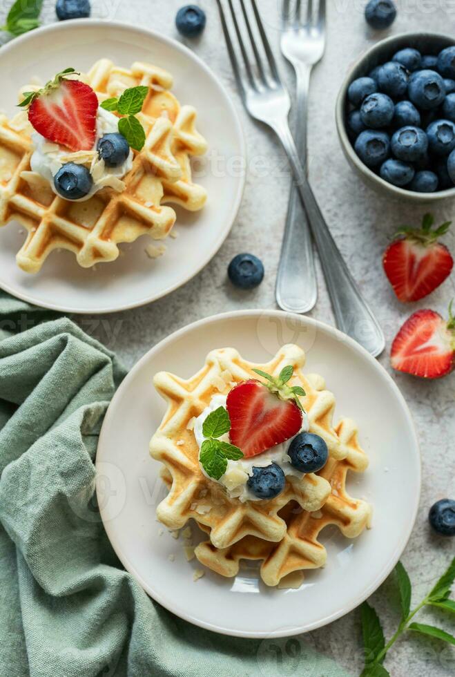 recién horneado gofres con fresas y arándanos foto