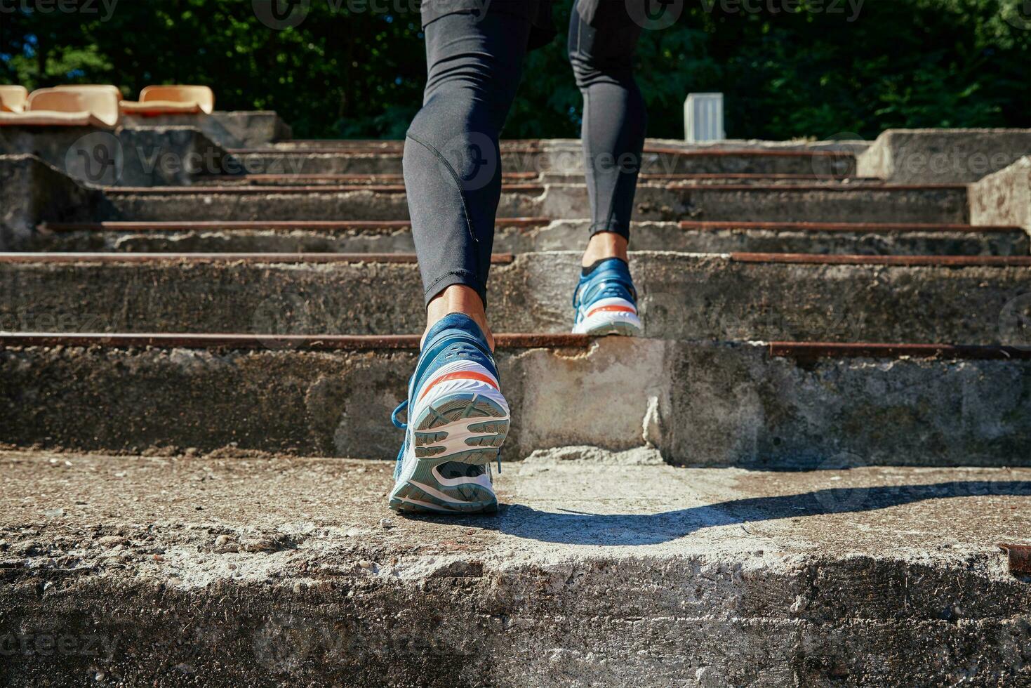 Male sprinter wearing running shoes training outdoors photo