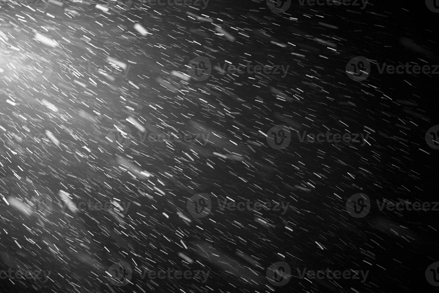 Falling snow flakes or rain on black background photo