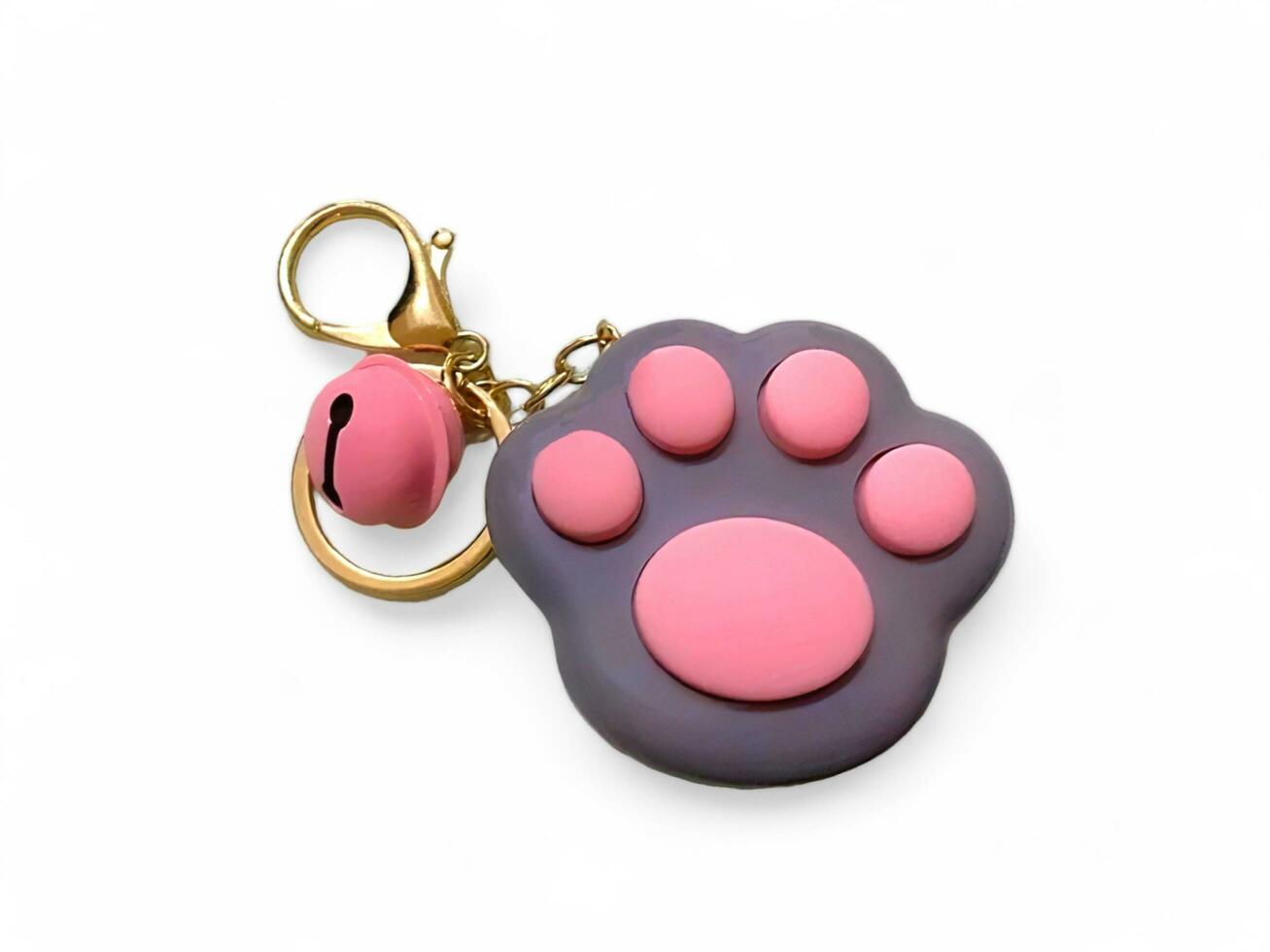 A toy key chain in the shape of a paw with a bell isolated on white photo