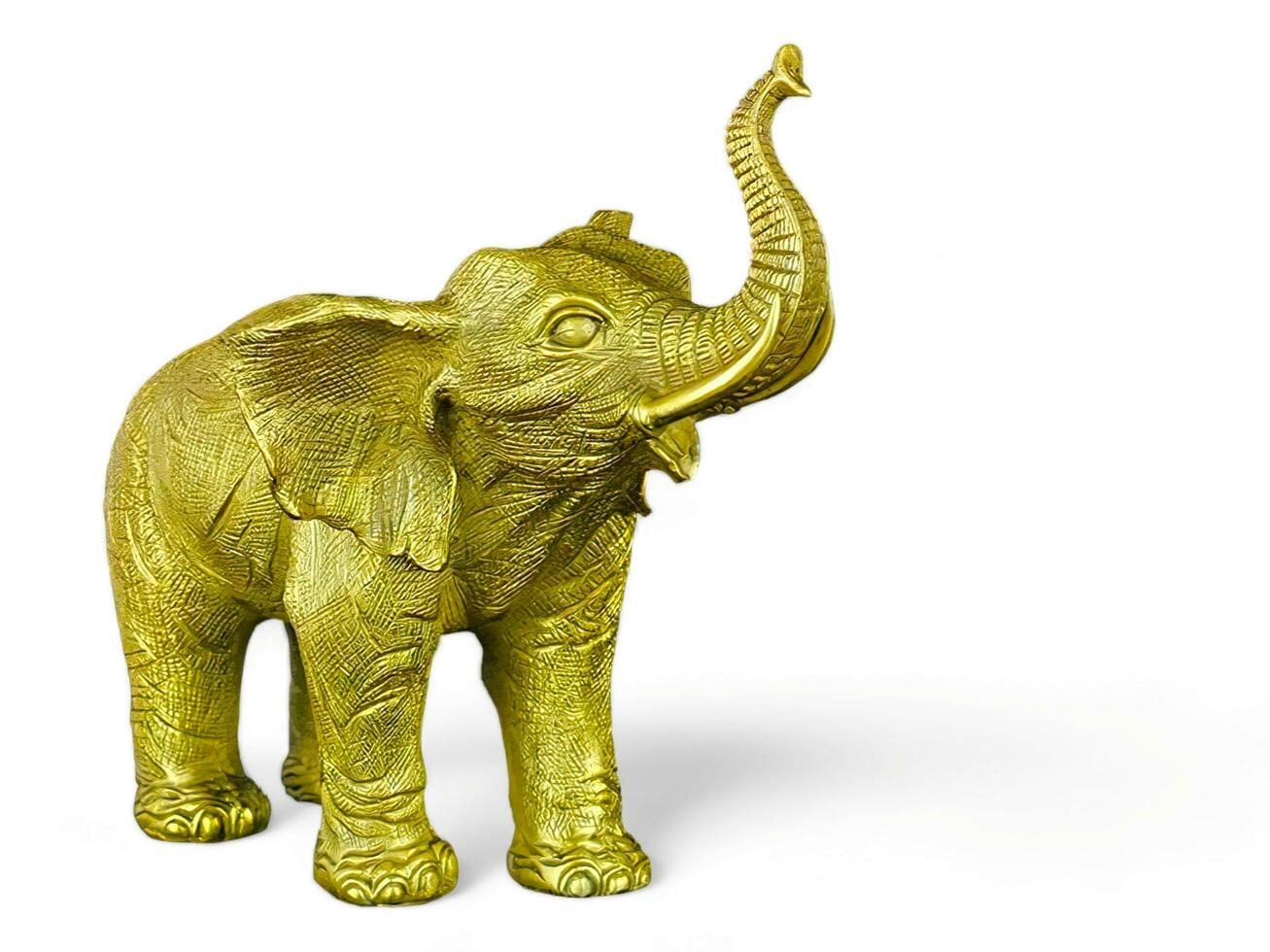 The elephant statue is gold in color on a white background photo
