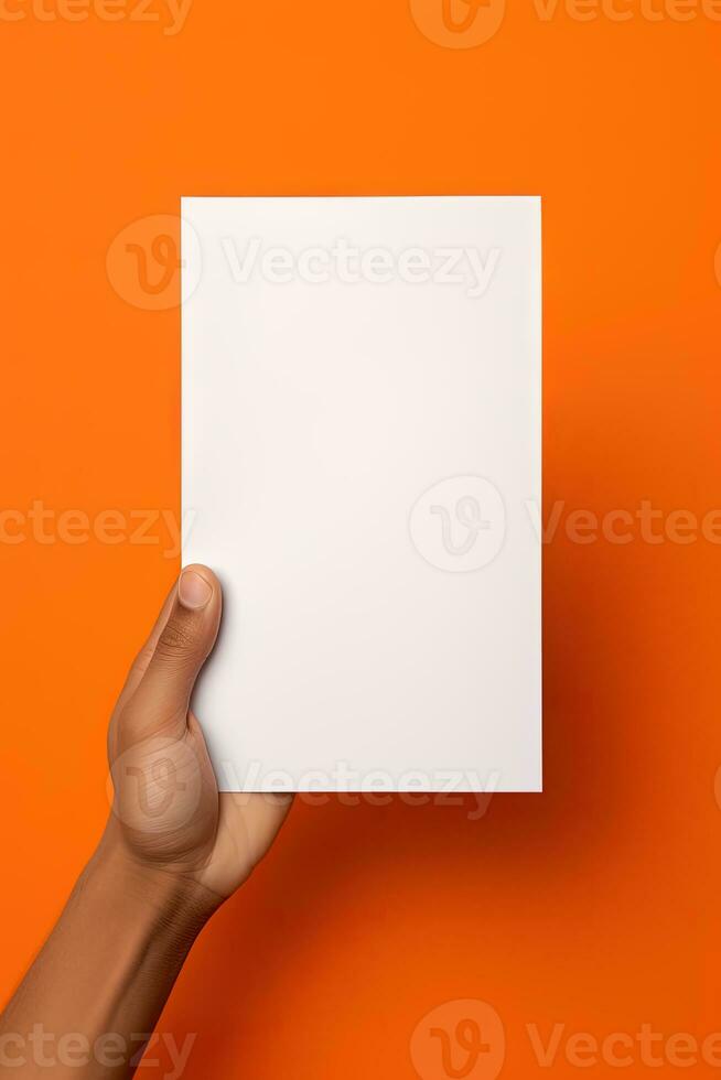 A human hand holding a blank sheet of white paper or card isolated on orange background. ai generated photo