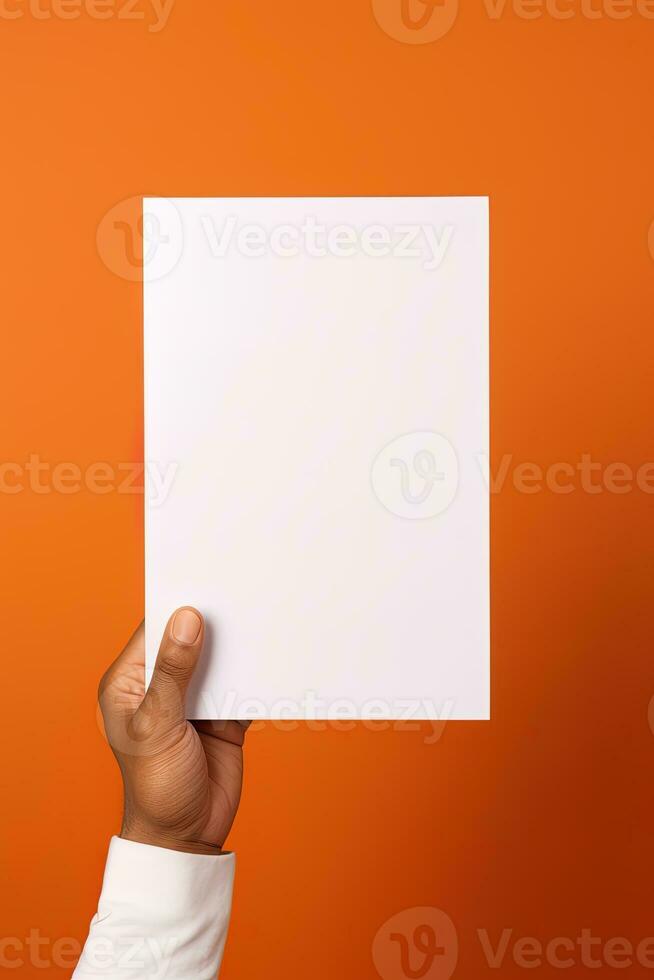 A human hand holding a blank sheet of white paper or card isolated on orange background. ai generated photo