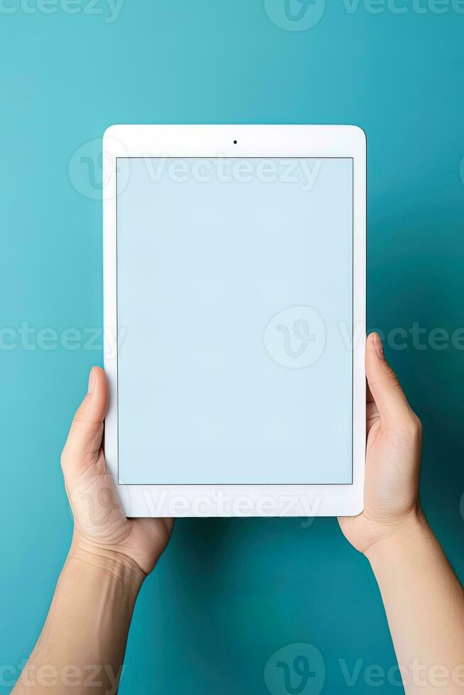 Hand holding tablet with mockup blank screen isolated on blue background. ai generated photo