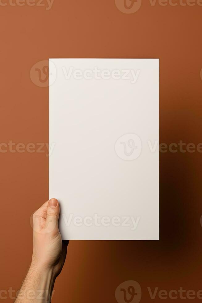A human hand holding a blank sheet of white paper or card isolated on brown background. ai generated photo