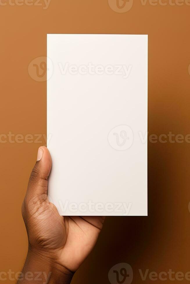 A human hand holding a blank sheet of white paper or card isolated on brown background. ai generated photo