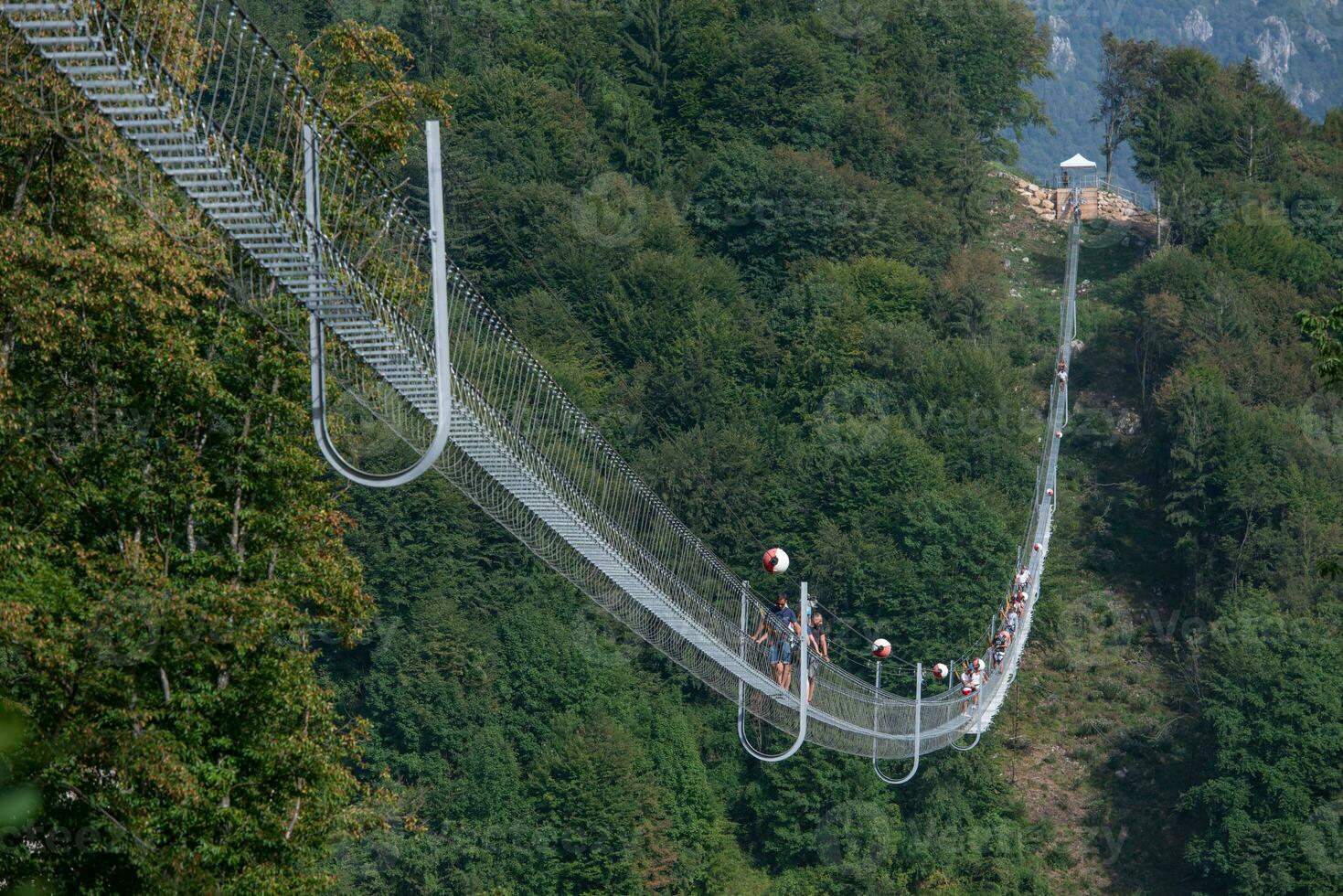 People while crossing the Tibetan bridge of Dossena.Which is the longest in the world photo
