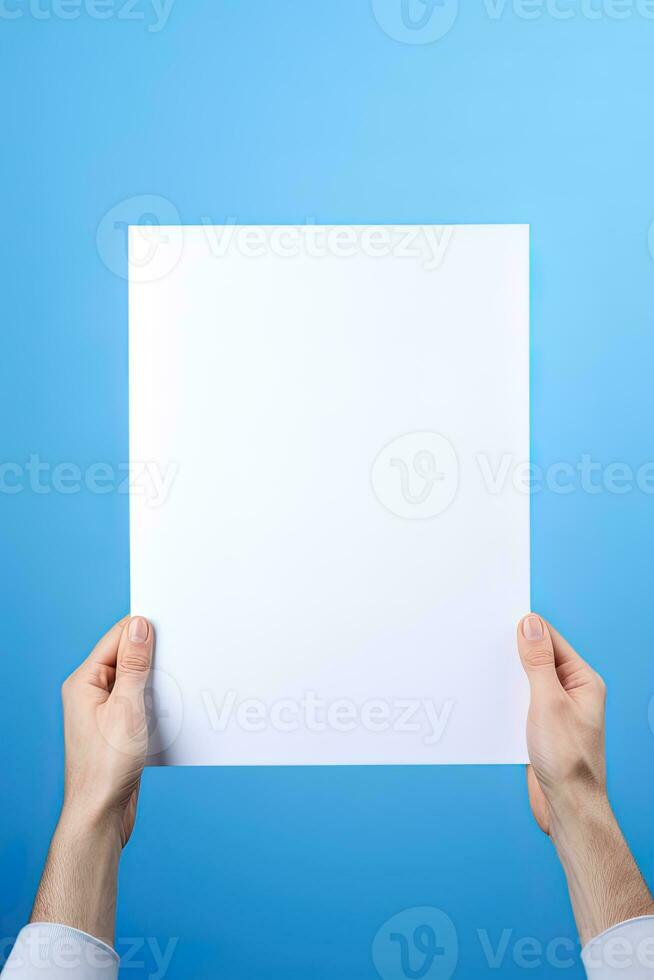 A human hand holding a blank sheet of white paper or card isolated on blue background. ai generated photo