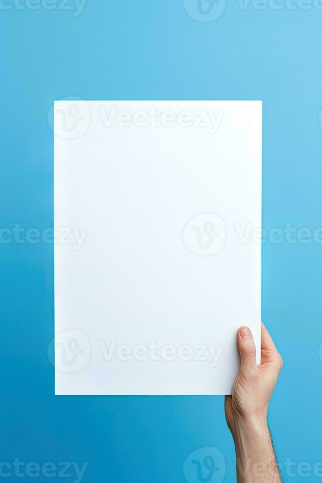 A human hand holding a blank sheet of white paper or card isolated on blue background. ai generated photo