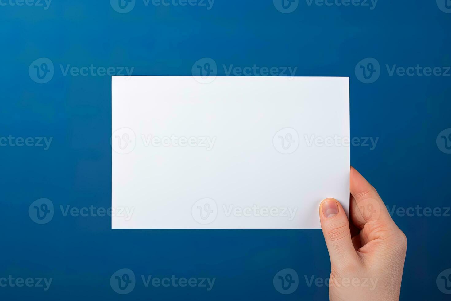 A human hand holding a blank sheet of white paper or card isolated on blue background. ai generated photo