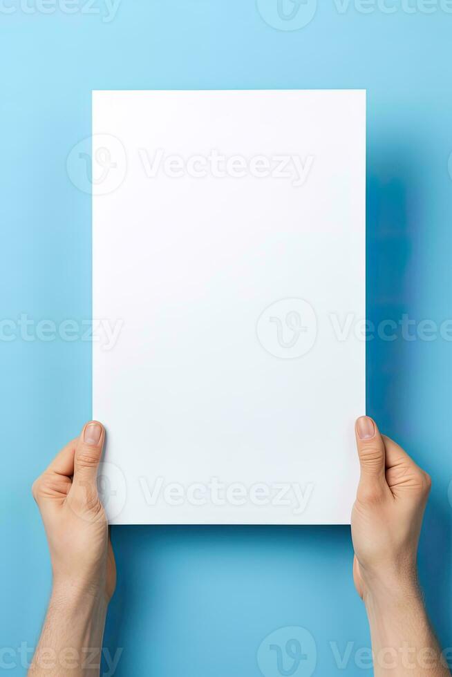A human hand holding a blank sheet of white paper or card isolated on blue background. ai generated photo
