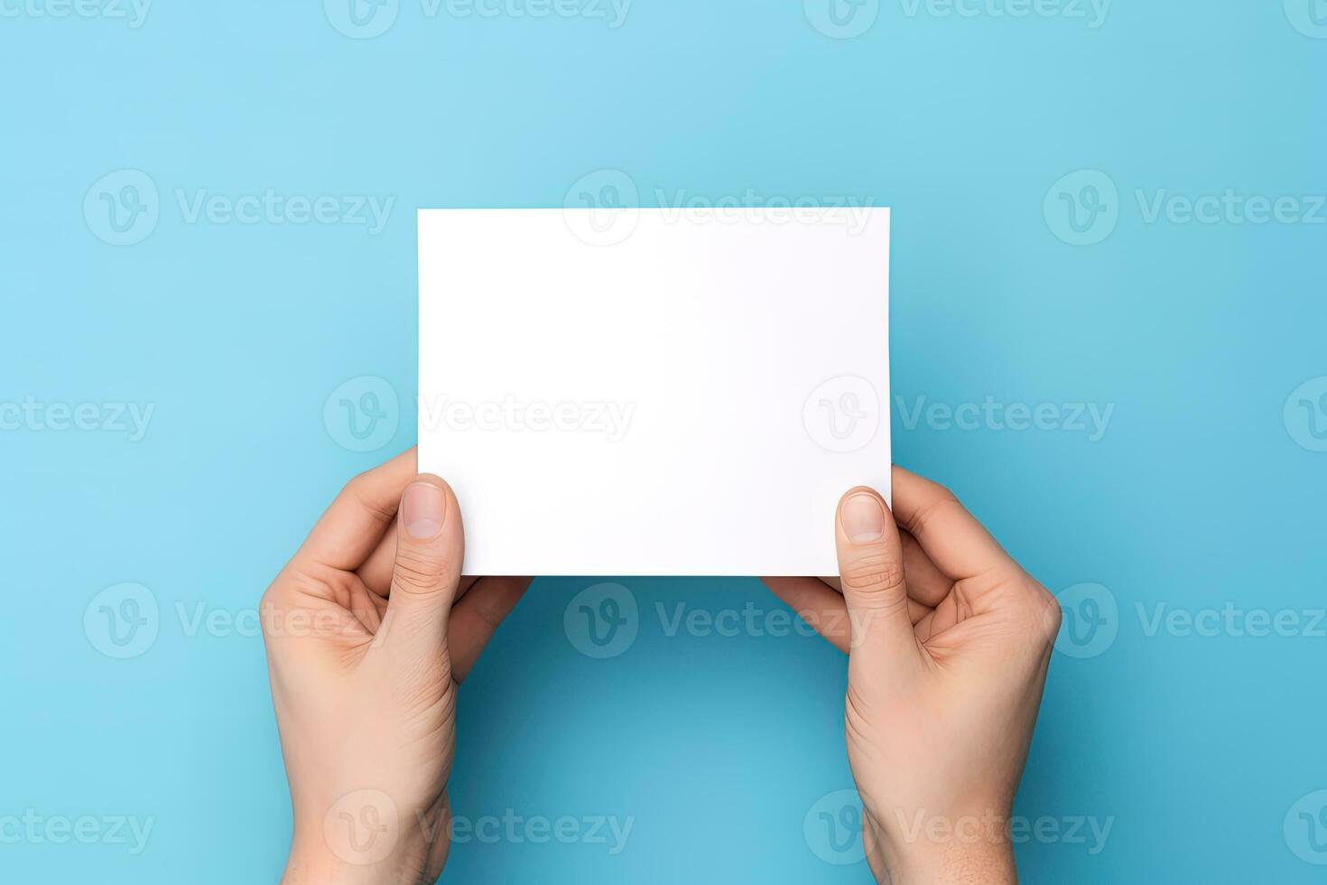 A human hand holding a blank sheet of white paper or card isolated on blue background. ai generated photo