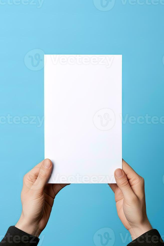 A human hand holding a blank sheet of white paper or card isolated on blue background. ai generated photo