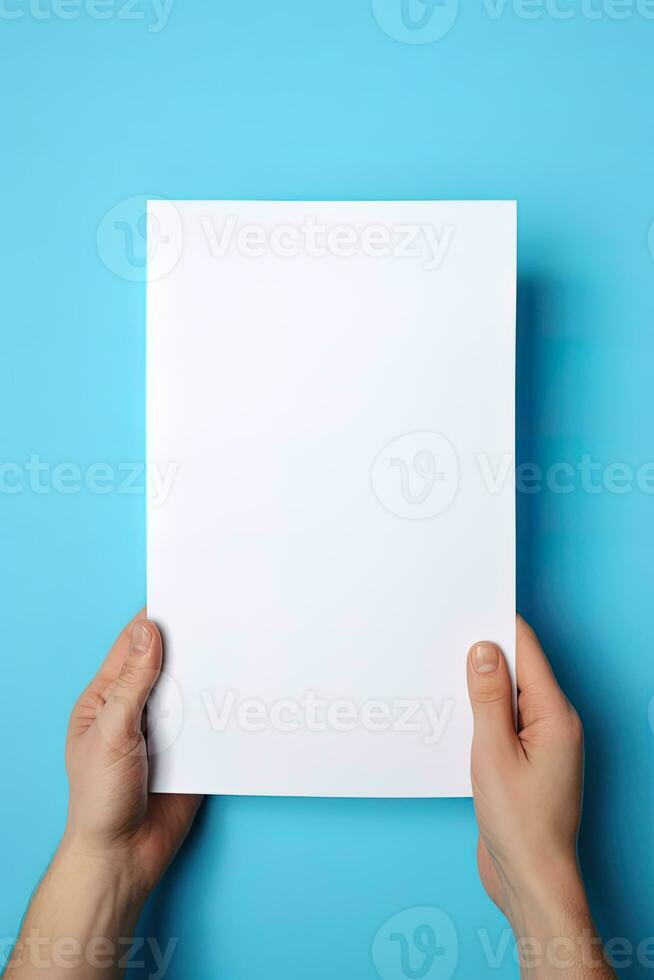 A human hand holding a blank sheet of white paper or card isolated on blue background. ai generated photo