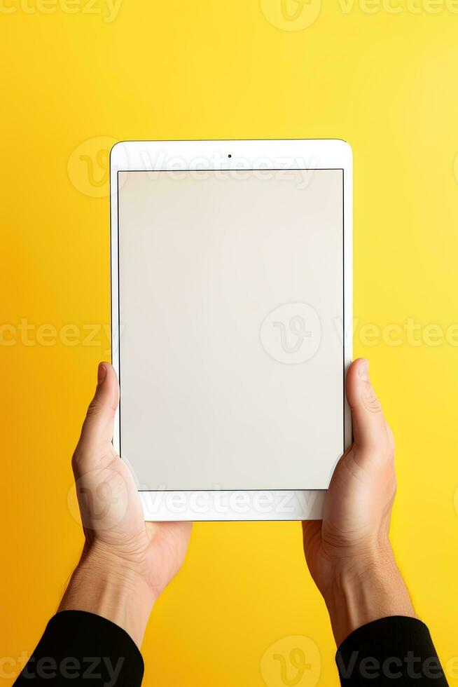 Hand holding tablet with mockup blank screen isolated on yellow background. ai generated photo