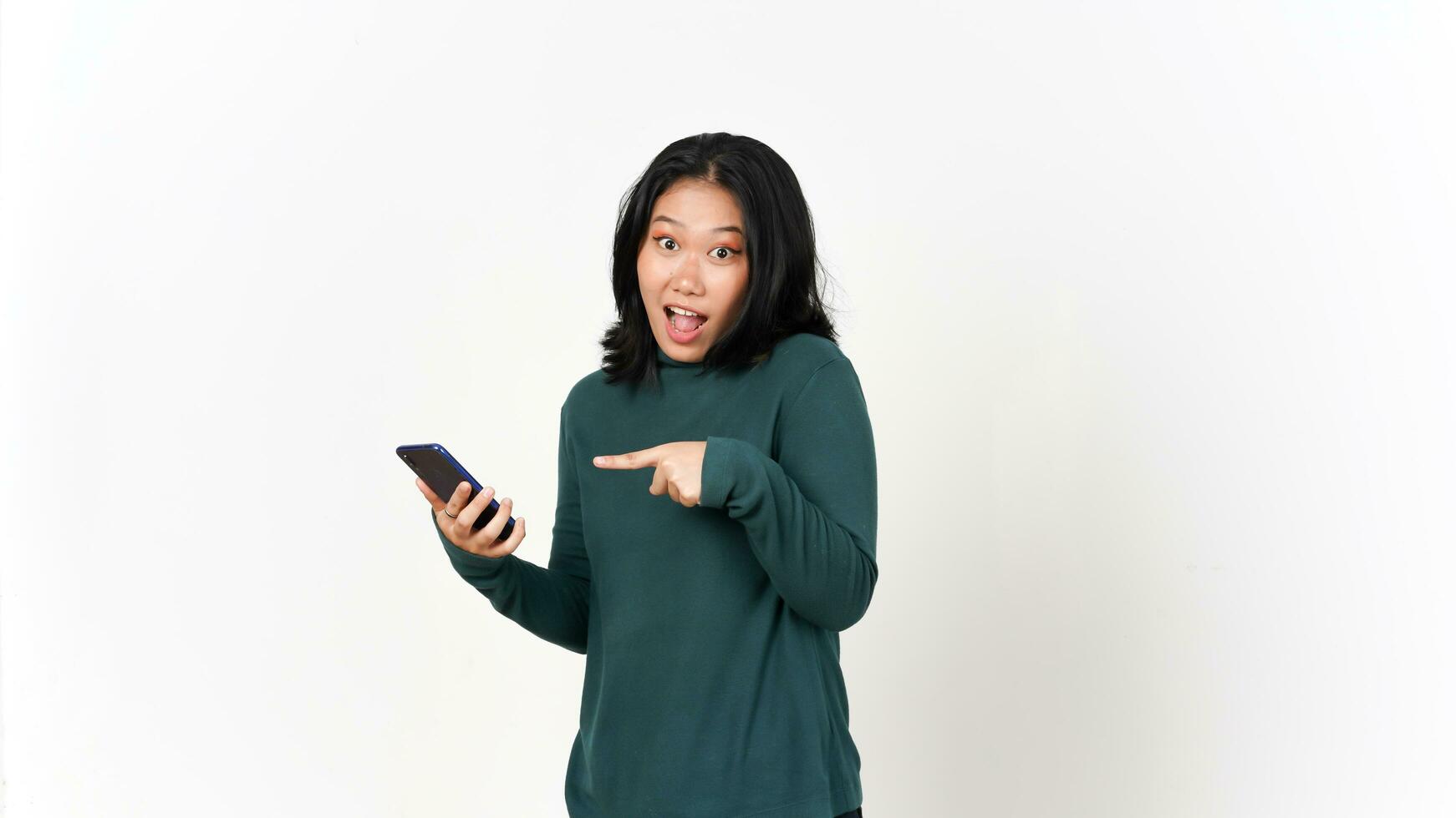 Holding Smartphone with Shocked Face and Pointing Smartphone Of Beautiful Asian Woman Isolated On White Background photo