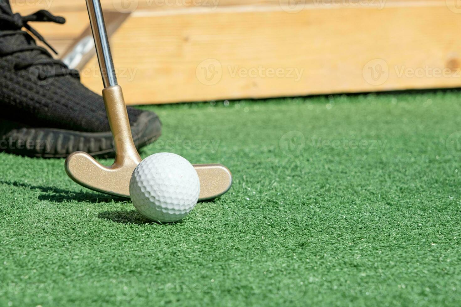 unrecognizable person playing mini golf photo