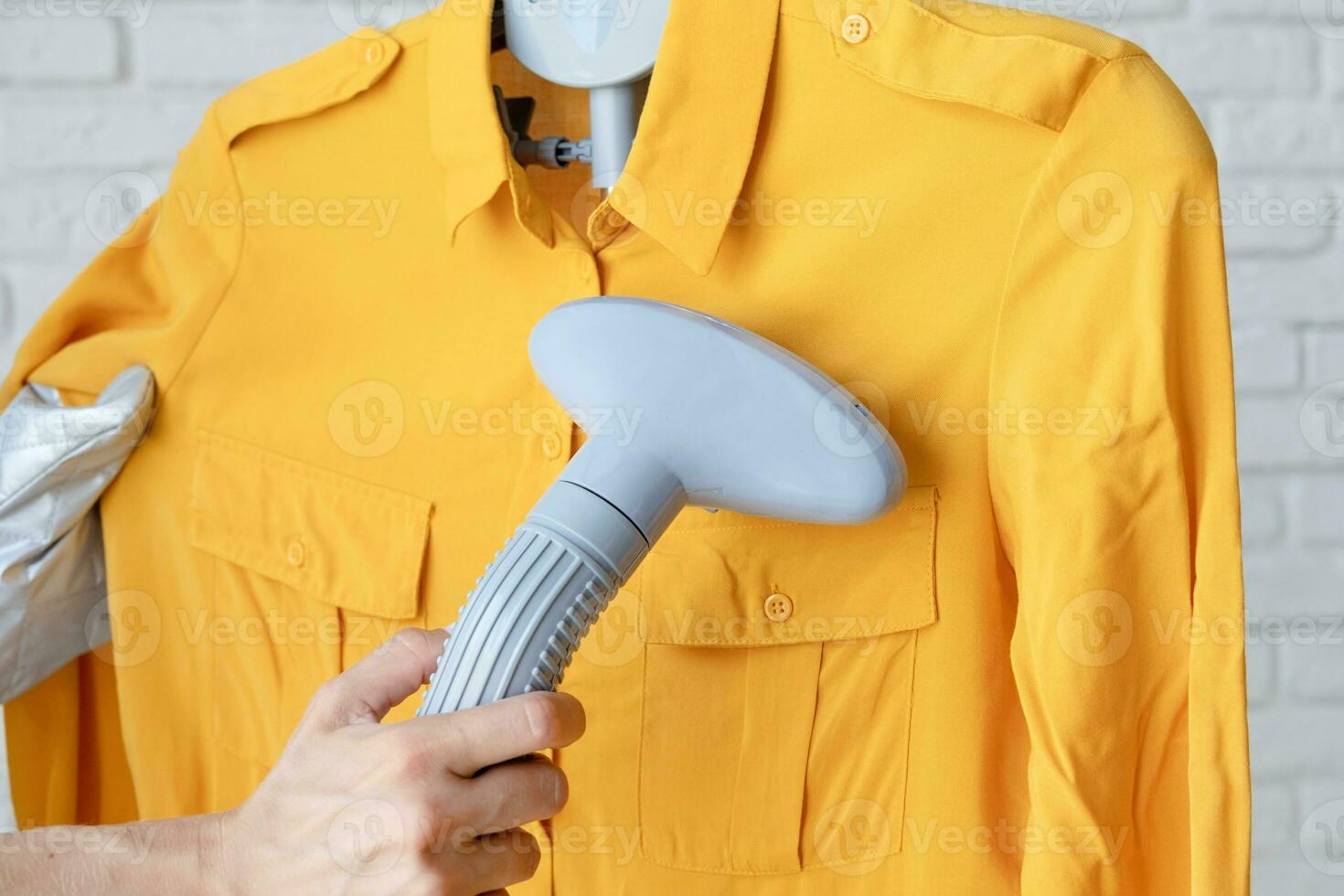 female hand using vertical steamer steaming clothes photo