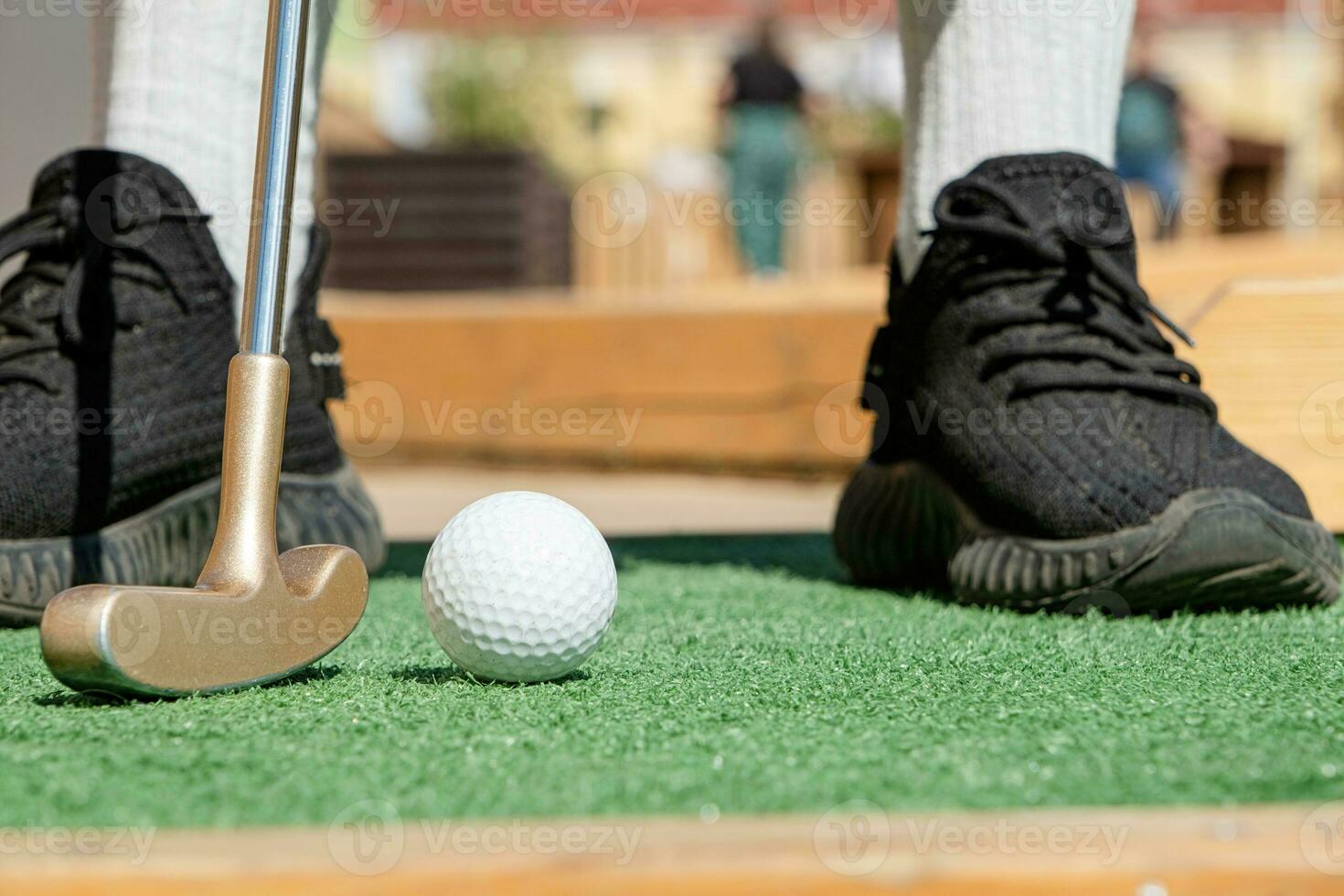 unrecognizable person playing mini golf photo