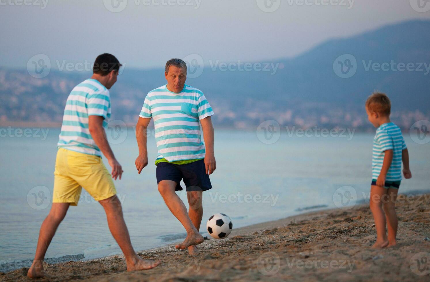 familia equipo de Tres jugando fútbol americano a el playa foto