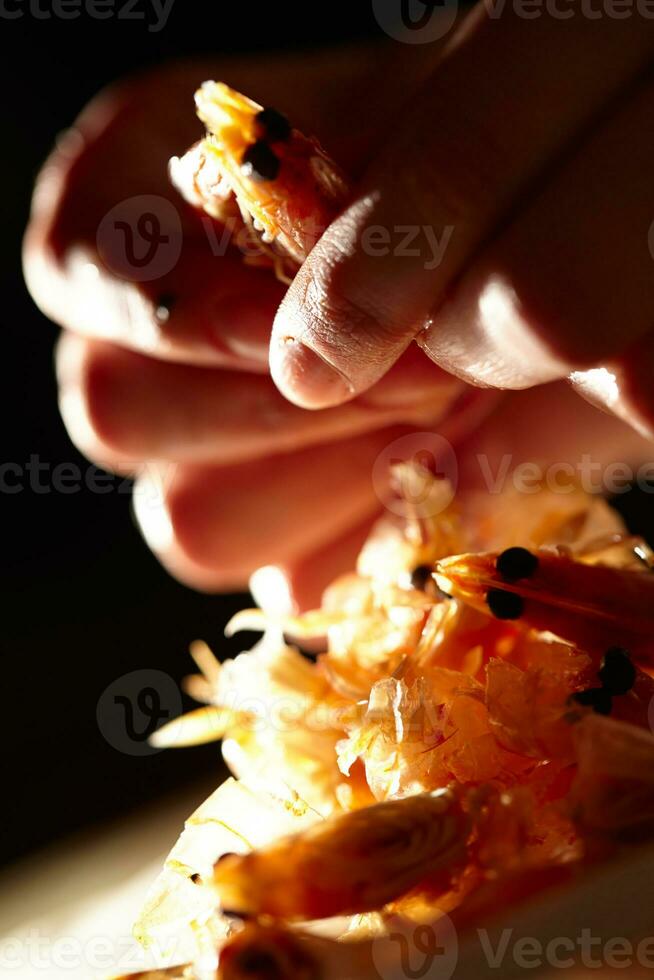 Shrimp in hands. Vertical shot. photo